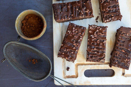 Sliced brownies with chocolate glaze on wooden cutting board