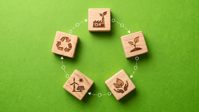 Sustainable development concept featuring wooden blocks with ecology icons representing renewable energy and recycling on green background