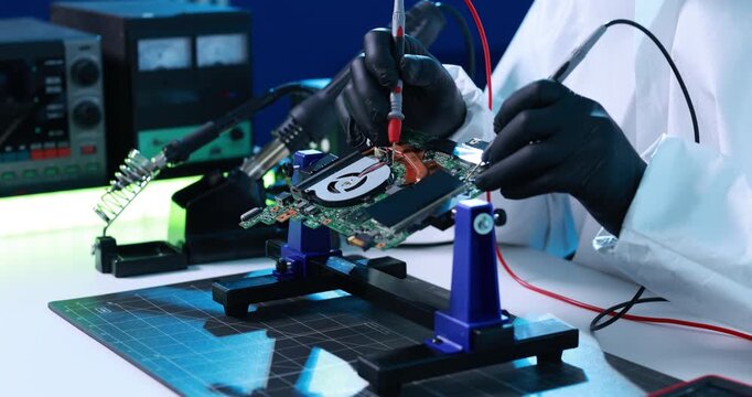 Technician in protective gloves tests a hard drive circuit board with probes at an electronics repair workstation.