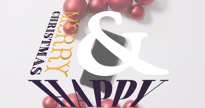Glossy red ornaments clustering near gold MERRY and dark CHRISTMAS on gray surface, copy space