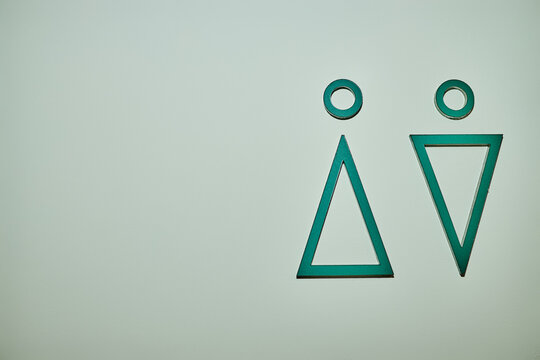 Minimalist green geometric restroom signs indicating male and female toilet entrance with copy space. Useful for modern interior navigation, signage branding, and public facility UI