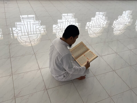 Muslim Man Reading Quran in Mosque