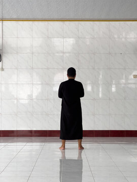 Man Standing in Prayer Inside a Mosque