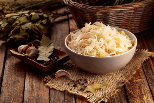Sauerkraut with ingredients on a rustic background.