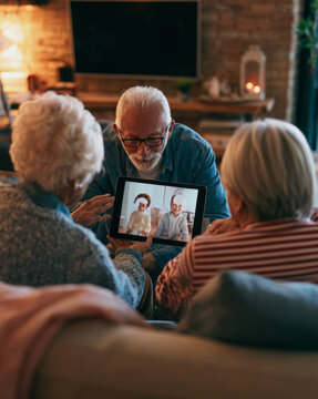 Grandparents video calling grandchildren on tablet at home in Family Lifestyle Setting