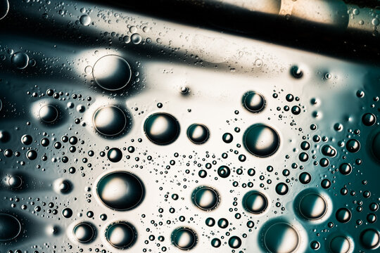 Reflective water droplets forming an abstract teal macro pattern