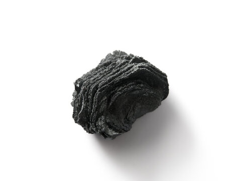 Isolated hematite specimen, also known as Eisenbl&uuml;te. Small foliated black iron ore sample on white background. Private Swiss Alps mineral collection. Selective focus.