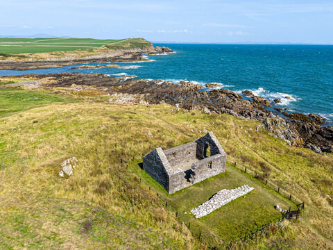 An aerial drone photograph of St Ninians Chapel (dating from the 1100s and rebuilt around 1300) on the coast of The Isle of Whithorn, Dumfries & Galloway, Scotland UK