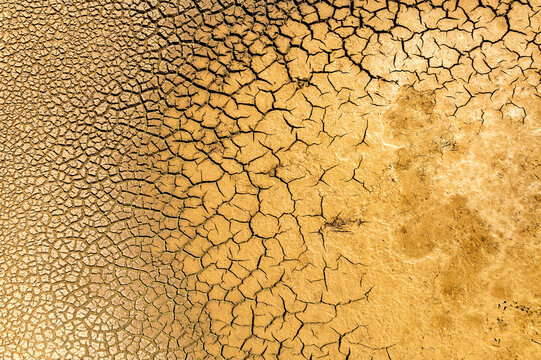 Cracked dry earth texture with patterns of drought-parched clay in arid landscape