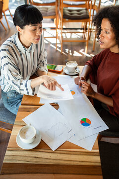 Two women reviewing charts in a cafe