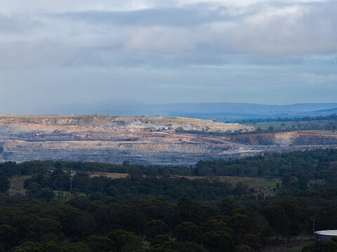 open cut coal mine scarring rural landscape in the Hunter valley seen on distant horizon