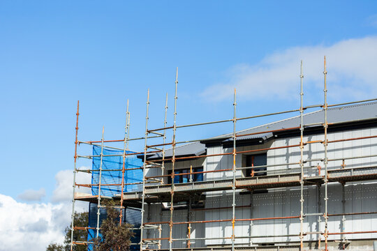 Scaffolding around second story of building under construction