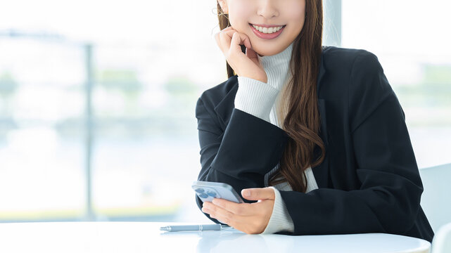スマートフォンを使う笑顔の女性・ビジネスウーマン