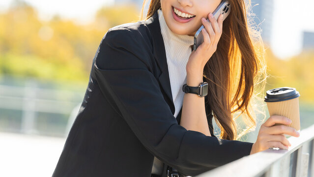 オフィス街でスマートフォンで話す女性・ビジネスウーマン