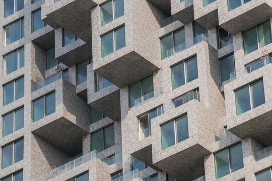 View of the geometric, modular facade of a modern apartment building with protruding balconies and glass windows in Tirane, Tirana County, Albania.