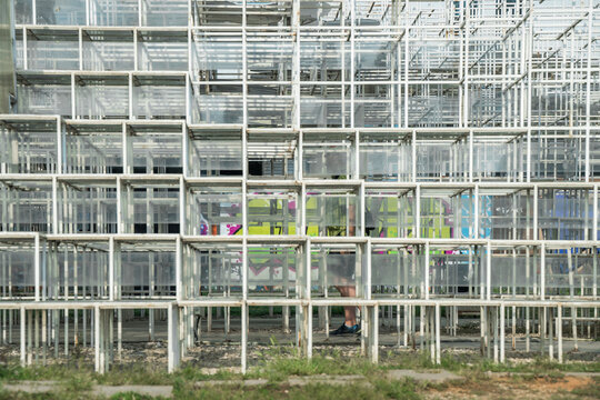 View of a modern white metal grid installation with a person walking behind it in Tirane, Tirana County, Albania.
