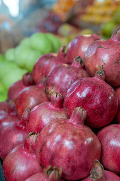 Fresh red pomegranate fruit harvest background. Organic ripe produce market pile display