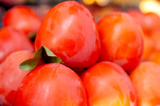 Fresh orange persimmon fruit harvest background. Organic ripe kaki produce market pile display
