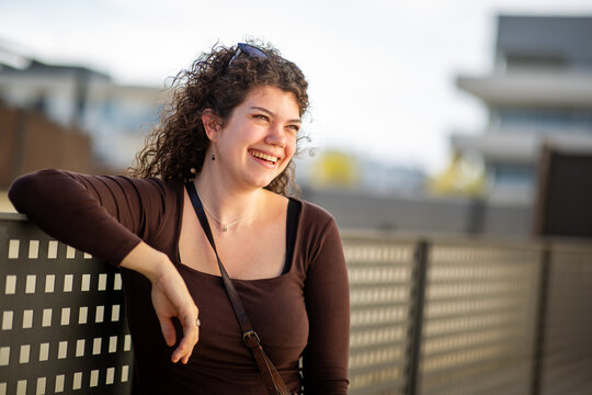 Cheerful young woman laughing outdoors with copy space in urban setting