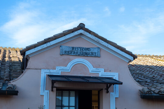 Rome, Italy - October 13, 2026: Pink building facade with Ristoro Refreshment sign and terracotta tile roof under blue sky in Rome, Italy
