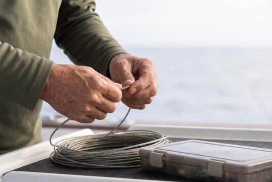 Hands preparing fishing line aboard a boat