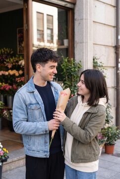 Teenage boy giving flowers to his girlfriend during a date