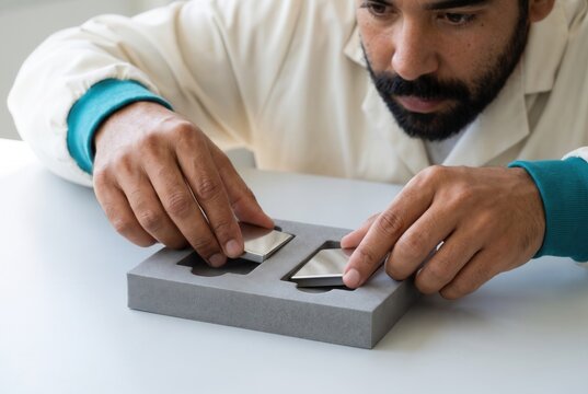 Technician comparing metal samples for quality control
