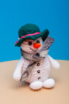 Snowman knitted from yarn, set against a colorful background