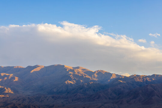 Mountain Range Under Bright Blue Sky with Clouds