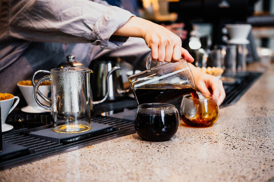 Barista making pour-over coffee in a cafe.