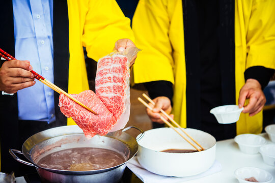 Thinly sliced Japanese Wagyu beef being prepared for Japanese hot pot dish called shabu-shabu.