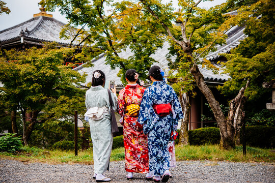 Women wearing traditional japanese kimonos walk along one of the streets in Kyoto, Japan.