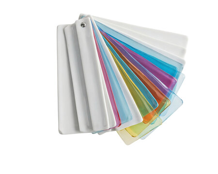 A fan deck of translucent plastic color swatches in various vibrant hues, featuring a white plastic handle and a metal rivet fastener isolated on a transparent background