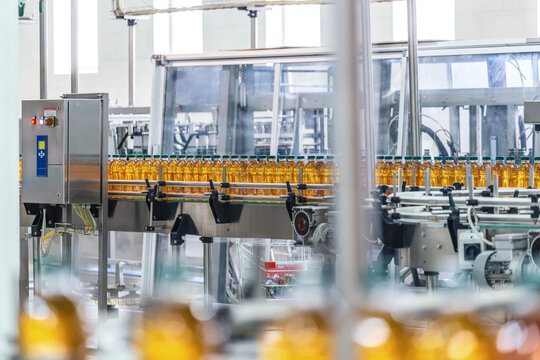 Automated Beverage Production Line with Plastic Bottles Moving Through Industrial Factory, Mass Manufacturing and Packaging Workflow on Conveyor