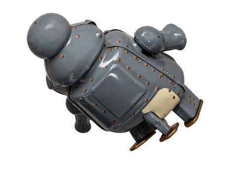 A vintage grey metal wind-up toy robot with copper rivets, rounded head, and flat feet, captured from a angle view isolated on a transparent background