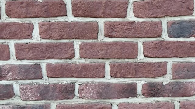 Close-up of red brick wall with white mortar joints. Thick cement seams. Classic architectural texture, traditional building material, urban design element, timeless construction style.