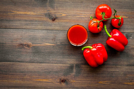 Red detox beverage with paprika and tomatoes on dark wooden background top view copyspace