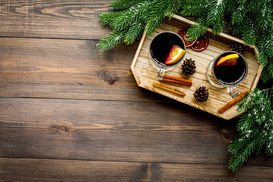 Winter tea with citrus fruits near spruce branch and pine cones on dark wooden background top view copyspace