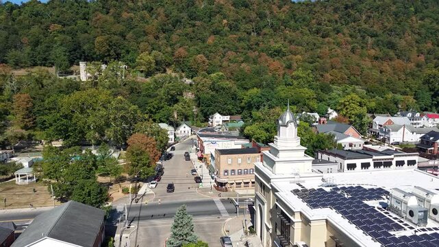 An aerial hyperlapse glides over Berkeley Springs, West Virginia, revealing its town streets and Appalachian hills in early autumn.