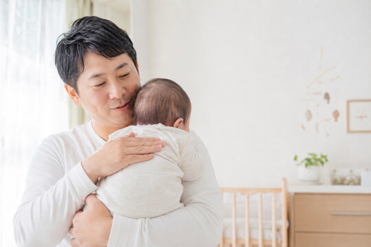 赤ちゃんを肩に抱く日本人の父親