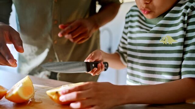 Kid slicing fresh oranges kitchen board. Parent guides child knife skills home.