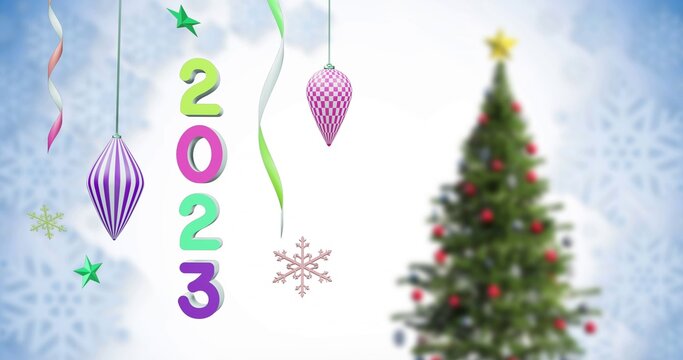 Colorful 2023 numerals hanging near evergreen tree holding red baubles and golden star