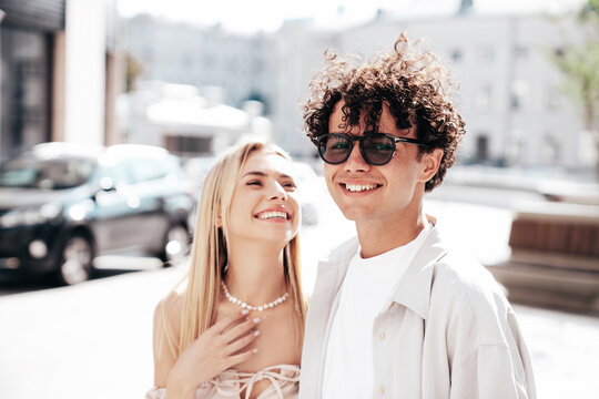 Young smiling beautiful woman and her handsome boyfriend in casual summer clothes. Happy cheerful family. Female having fun. Couple posing in the street background at sunny day