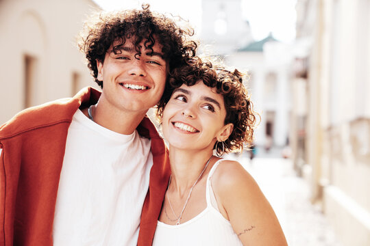 Young smiling beautiful woman and her handsome boyfriend in casual summer white t-shirt and jeans clothes. Happy cheerful family. Female having fun. Couple posing in the street background