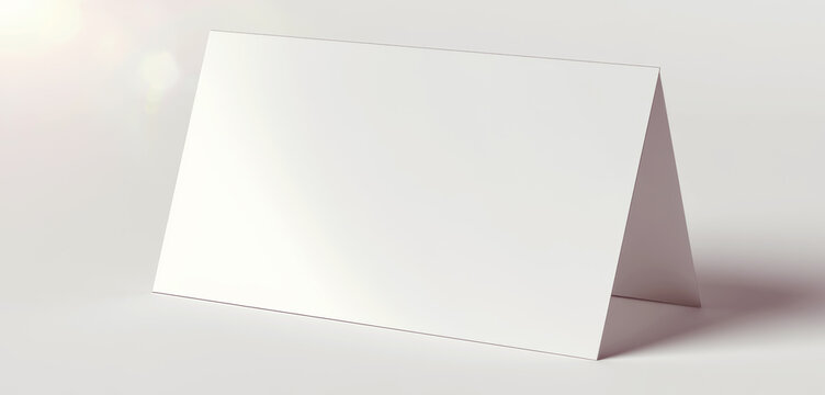Blank white folded card mockup standing on a neutral surface, offering a minimalist template for greetings, branding, and event displays