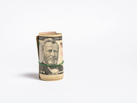 Rolled Stack of Fifty Dollar Bills Secured with a Green Rubber Band