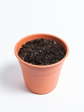 Terracotta Flower Pot Filled with Soil Isolated on White Background