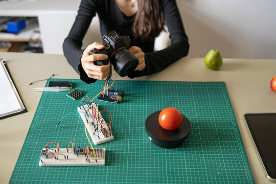 Woman Using Camera to Analyze Tomato Weight for AI Powered Object Recognition System