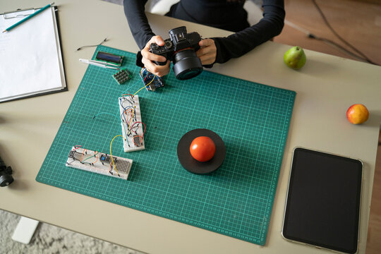 Overhead View of Woman Weighing and Photographing Tomato for AI Recognition Testing