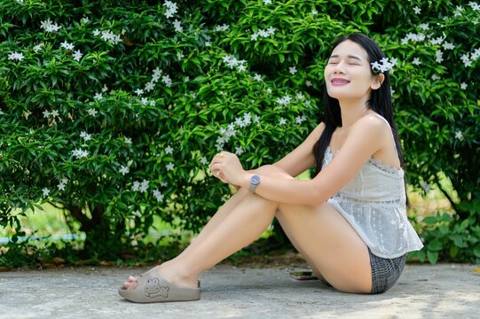 Woman Enjoying Nature with Flowers on a Sunny Day in the Garden